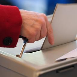Eine Frau wirft einen Wahlzettel in die Urne zur Bundestagswahl.