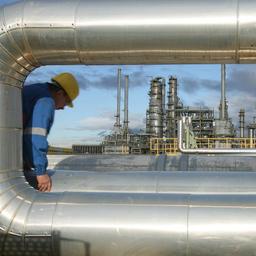 In der Raffinerie in Leuna geht ein Mitarbeiter an den Rohren einer Pumpstation entlang.