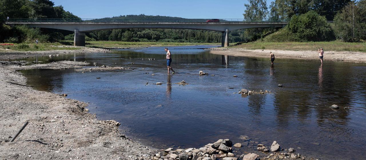 Eine Familie überquert am 14. August 2026 im Dorf Nova Pec den Fluss Moldau