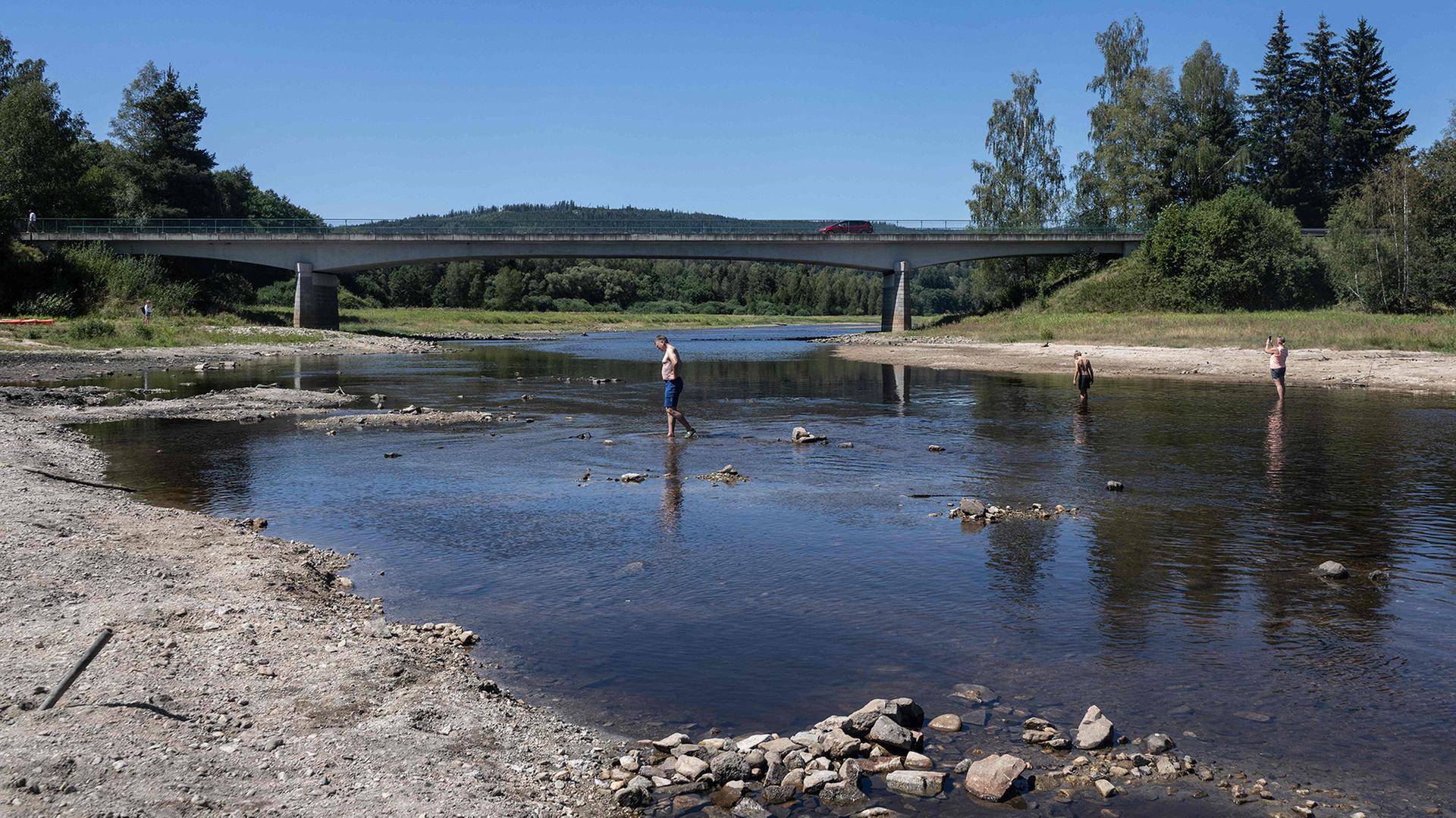 Eine Familie �berquert am 14. August 2026 im Dorf Nova Pec den Fluss Moldau | AFP