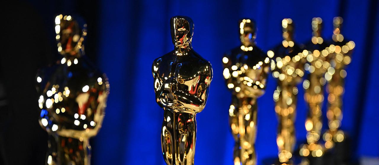 Mehrere Oscar-Statuetten stehen auf einem Tisch.