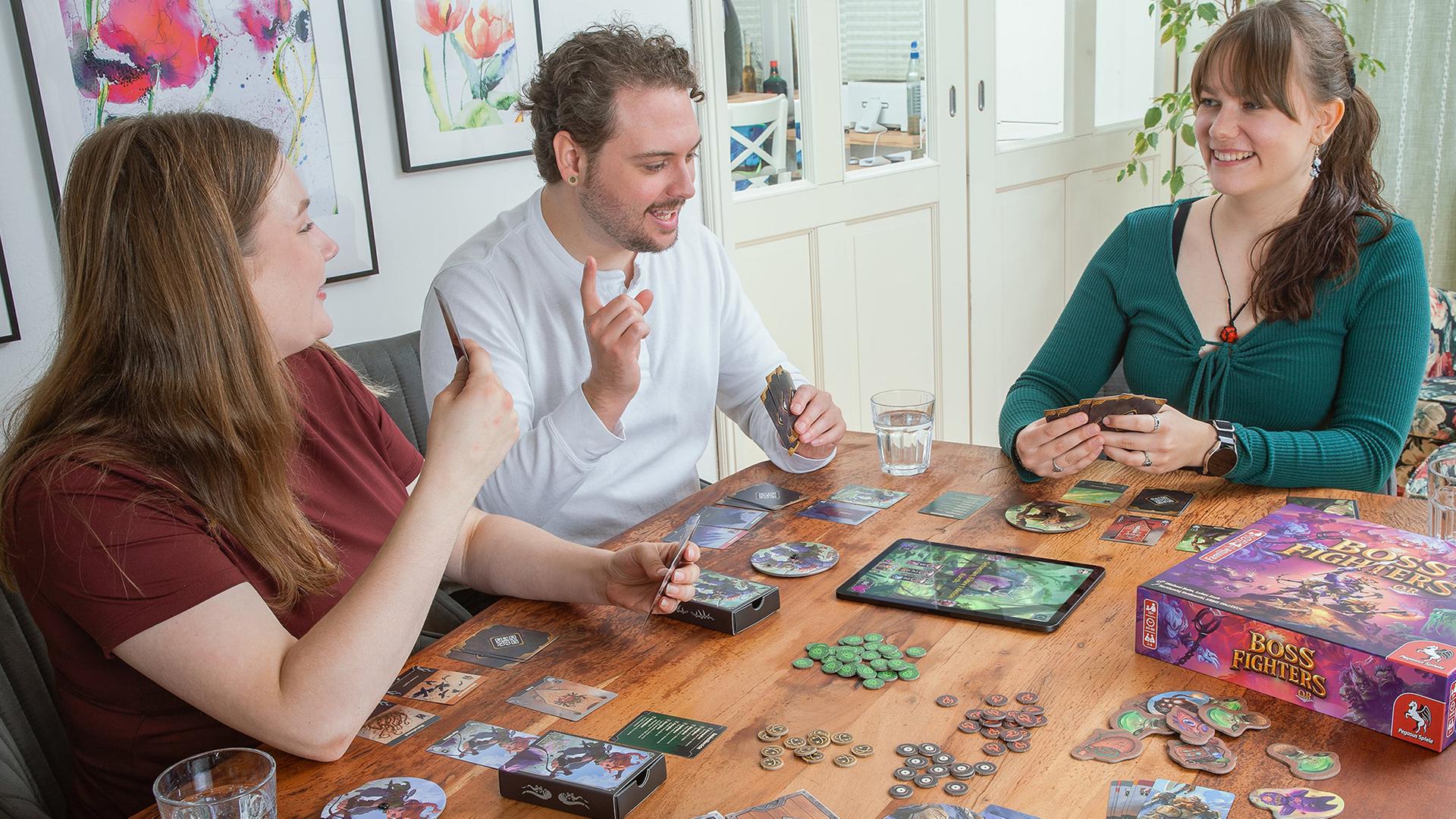 Zwei Frauen und ein Mann spielen das Spiel Bossfighter QR. | Pegasus Spiele