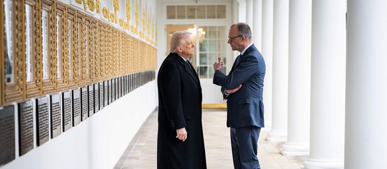 Donald Trump Friedrich Merz stehen in einem Säulengang und sprechen miteinander
