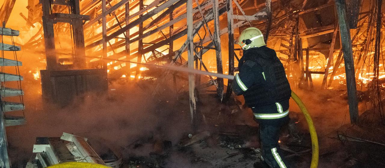 Ein Feuerwehrmann versucht einen Brand in Charkiw zu löschen.