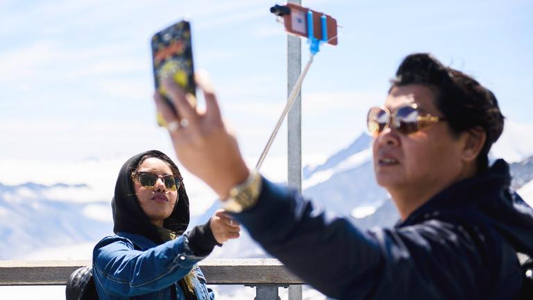 Touristen machen Selfies auf dem Jungfrauenjoch in der Schweiz.