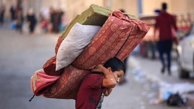 In Gaza-Stadt trägt ein Junge eine Matratze.