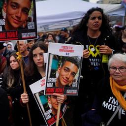 Menschen auf einer Kundgebung halten Plakate.
