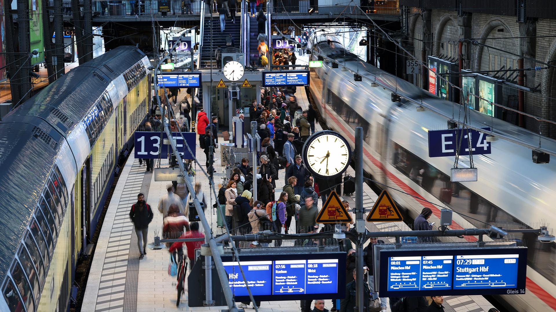 Reisende sind am Hauptbahnhof Hamburg auf dem Bahnsteig zwischen einem ICE und einem Regionalzug unterwegs.  | picture alliance/dpa