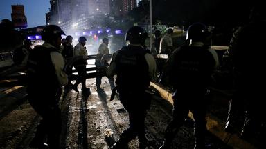 Die Stadtpolizei von Baruta entfernt eine Barrikade, während Menschen gegen die Wahlergebnisse protestieren.