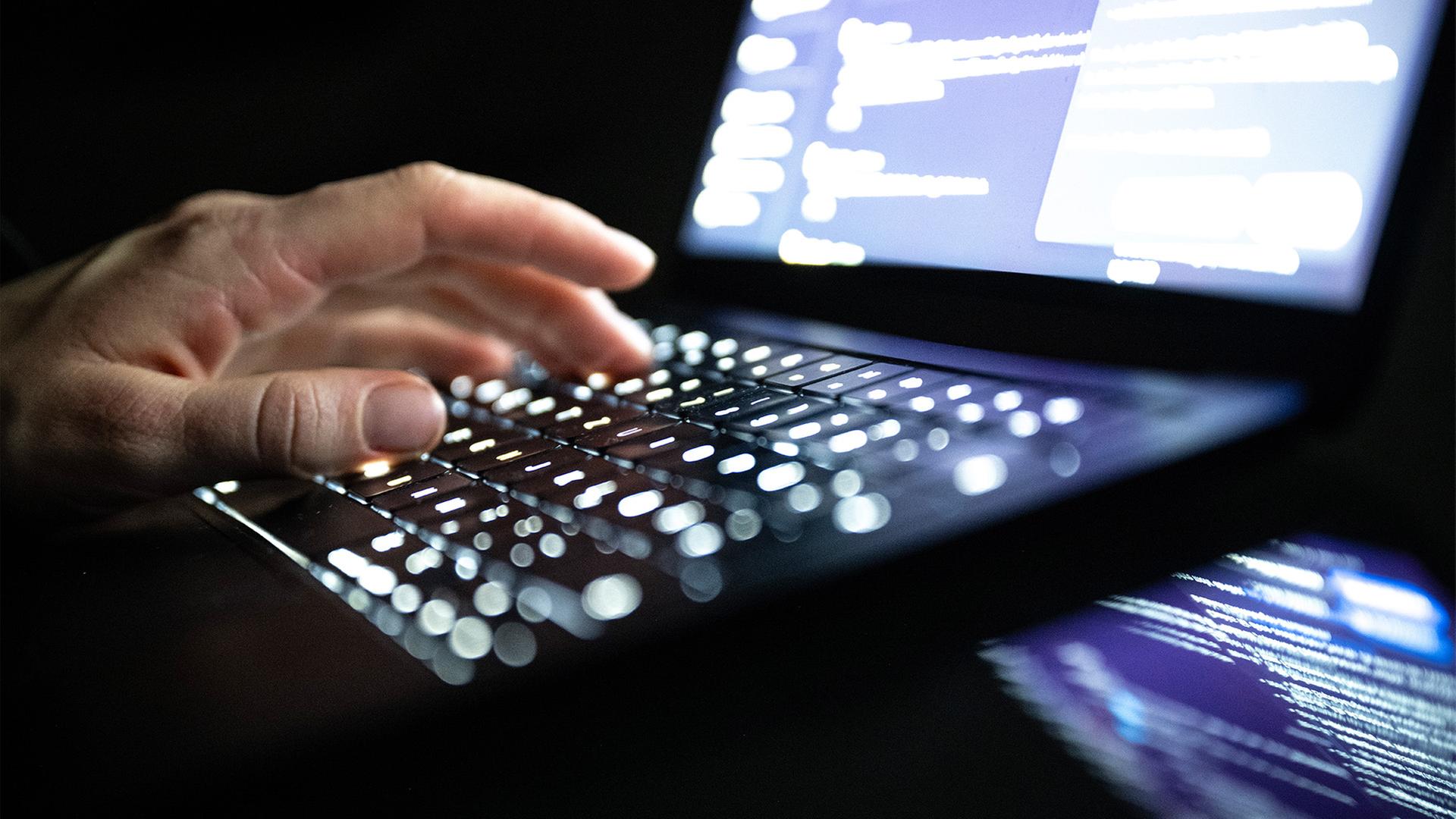 Eine Person tippt mit den Fingern auf einer beleuchteten Laptop-Tastatur. (Quelle: dpa/Dulian) | dpa/Dulian