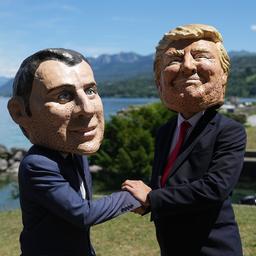 Bei einer Aktion der Organisation Oxfam in Evian sind Menschen mit Macron- und Trump-Masken zu sehen.