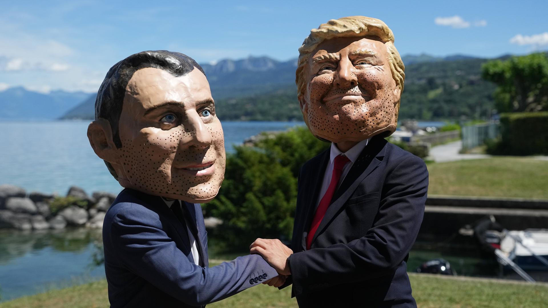Bei einer Aktion der Organisation Oxfam in Evian sind Menschen mit Macron- und Trump-Masken zu sehen. | AP Photo/Thibault Camus