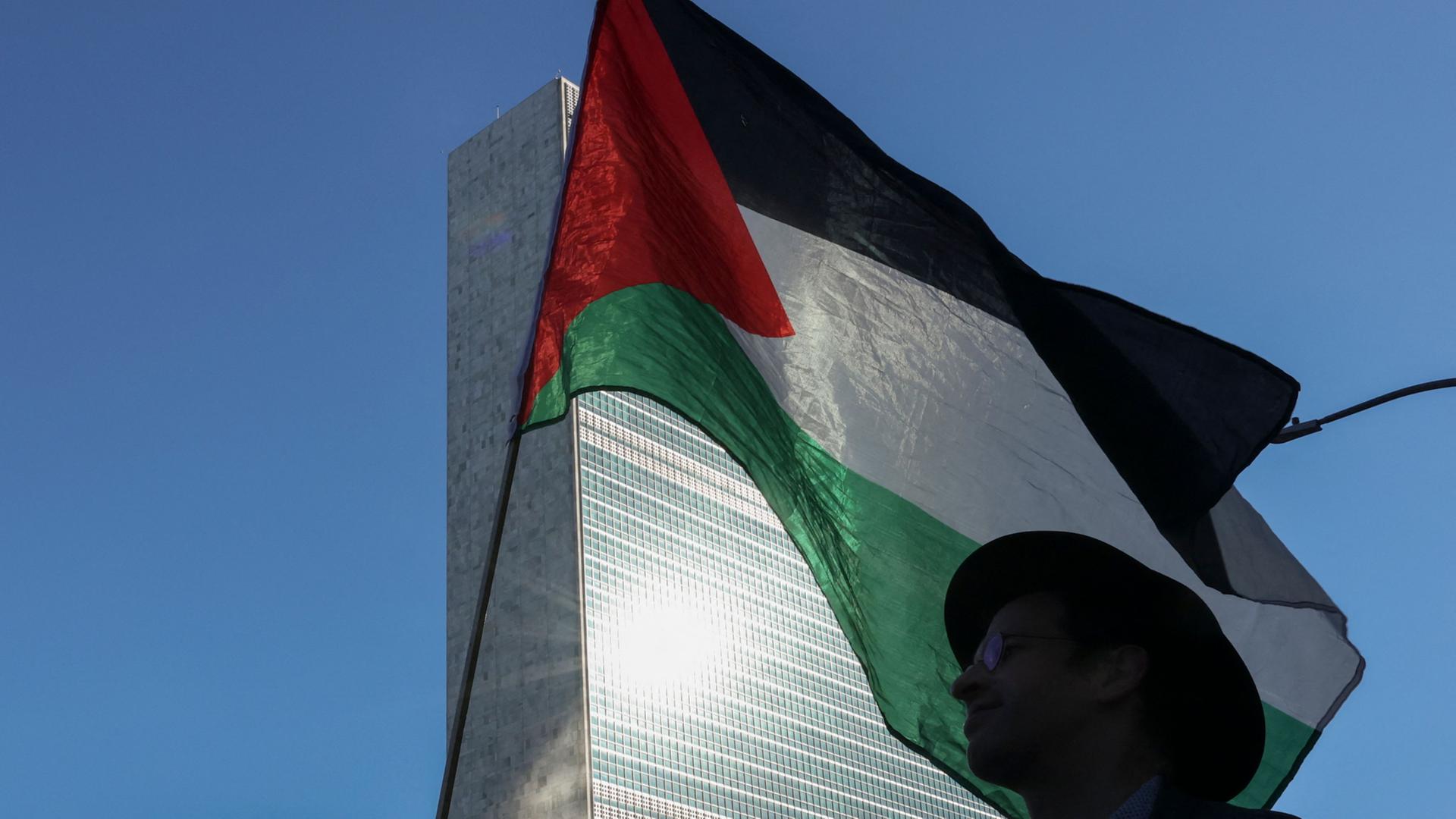 Ein Demonstrant mit einer palästinensischen Flagge vor dem UN-Hauptquartier in New York. | AFP