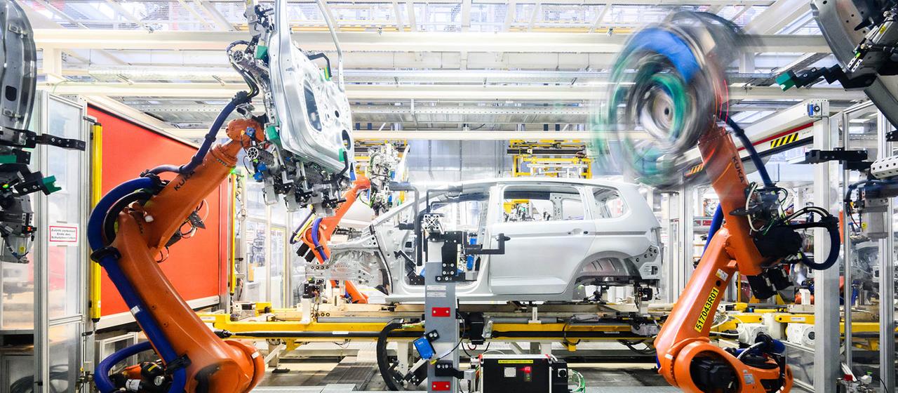 Roboter montieren im VW Stammwerk im Karosseriebau Türen an einen Neuwagen.
