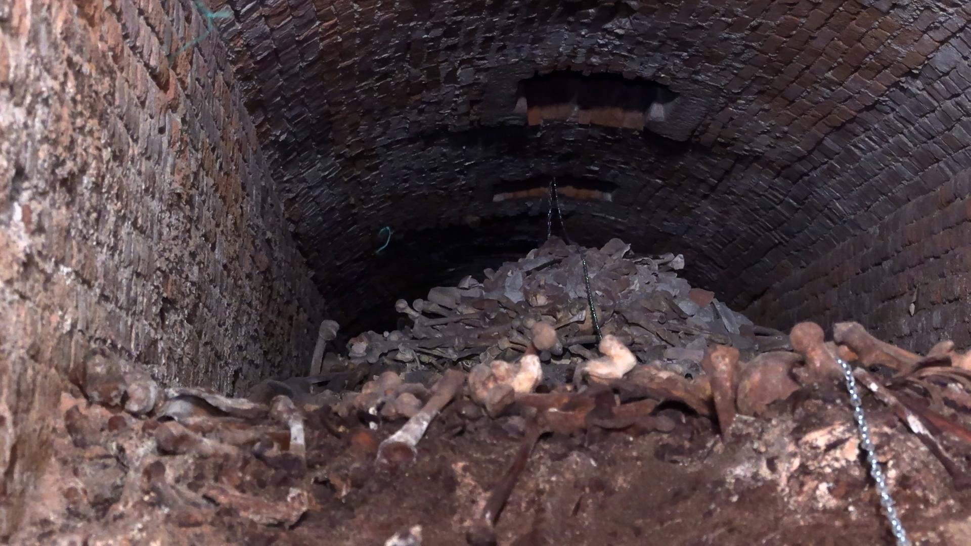Ein Berg voller menschlicher Knochen in einer dunklen Kammer.  | Jutta Hespelein