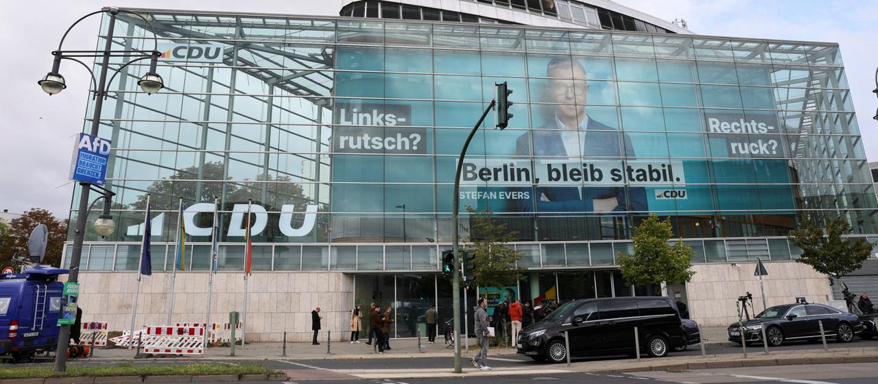 Menschen gehen in Berlin an der Zentrale der CDU vorbei.