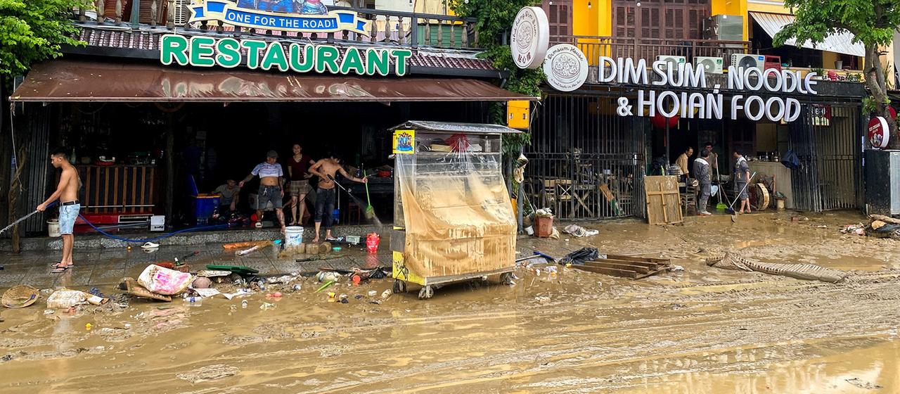 Menschen reinigen ein Restaurant nach Überschwemmungen in Zentralvietnam (Archivbild 1.112025).