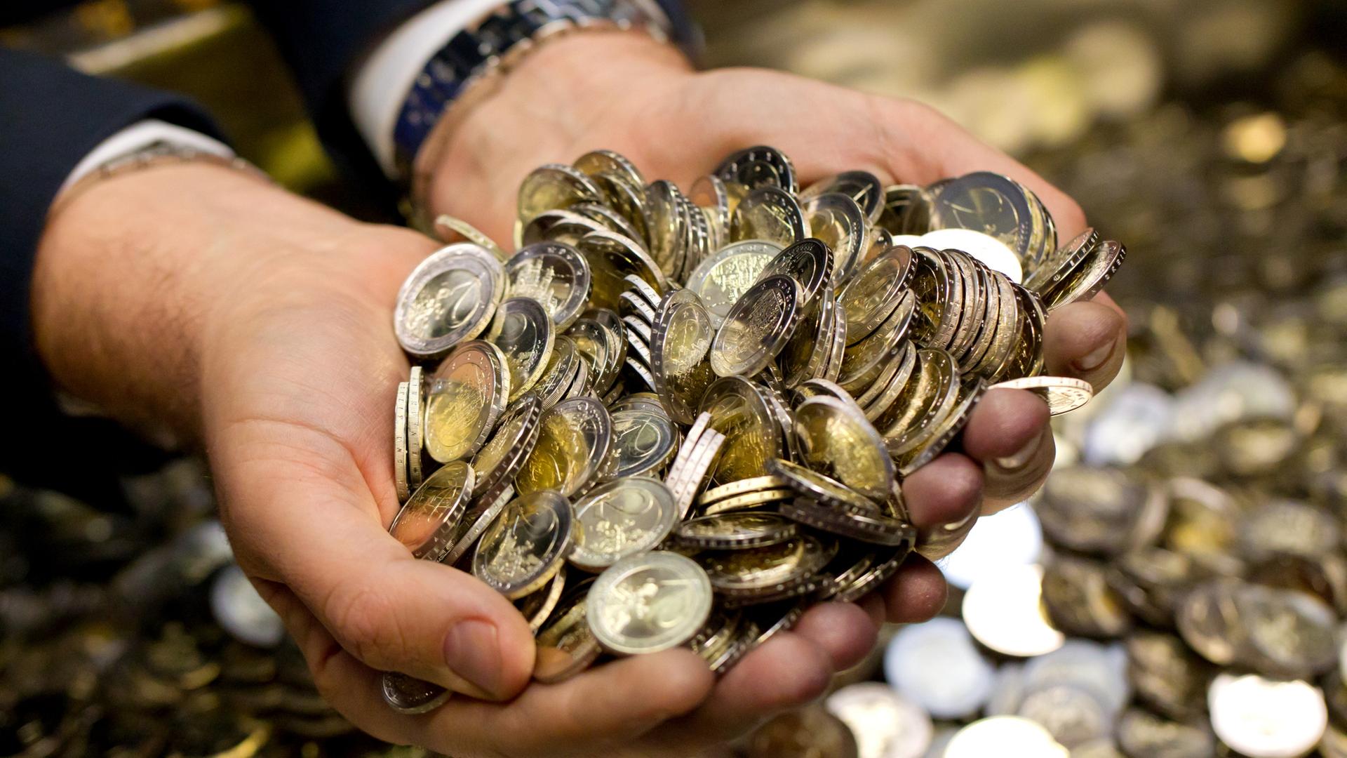 Symbolbild: Zwei Hände voller Euro-Münzen | dpa