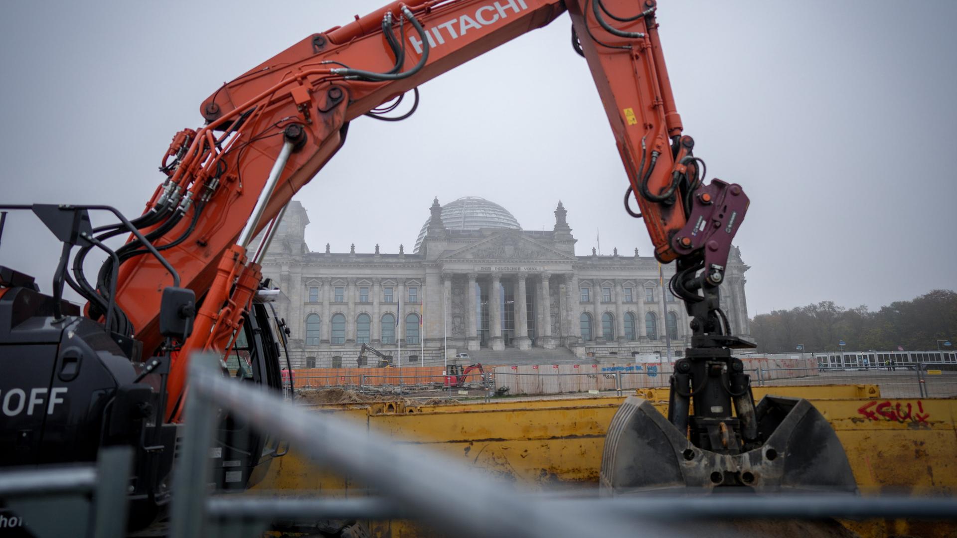 Ein Bagger steht auf einer Baustelle im Nebel vor dem Reichstagsgebäude in Berlin. | dpa