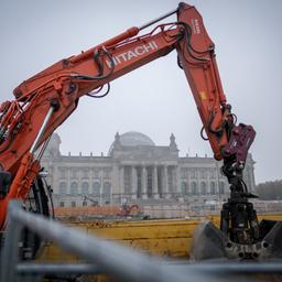 Ein Bagger steht auf einer Baustelle im Nebel vor dem Reichstagsgebäude in Berlin.