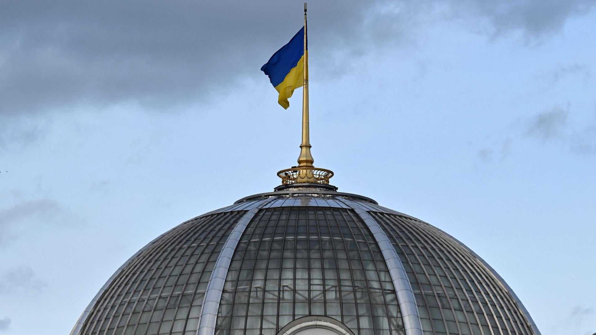 Die ukrainische Flagge weht über der Kuppel des Parlaments in Kiew. | AFP