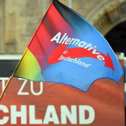 Eine Fahne mit dem Parteilogo der AfD weht während einer Kundgebung der AfD Sachsen-Anhalt auf dem Marktplatz in Dessau-Roßlau.