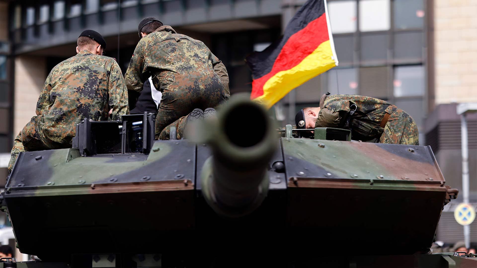 Bundeswehrsoldaten mit einer Deutschlandfahne auf einem Panzer. | picture alliance / Panama Pictur
