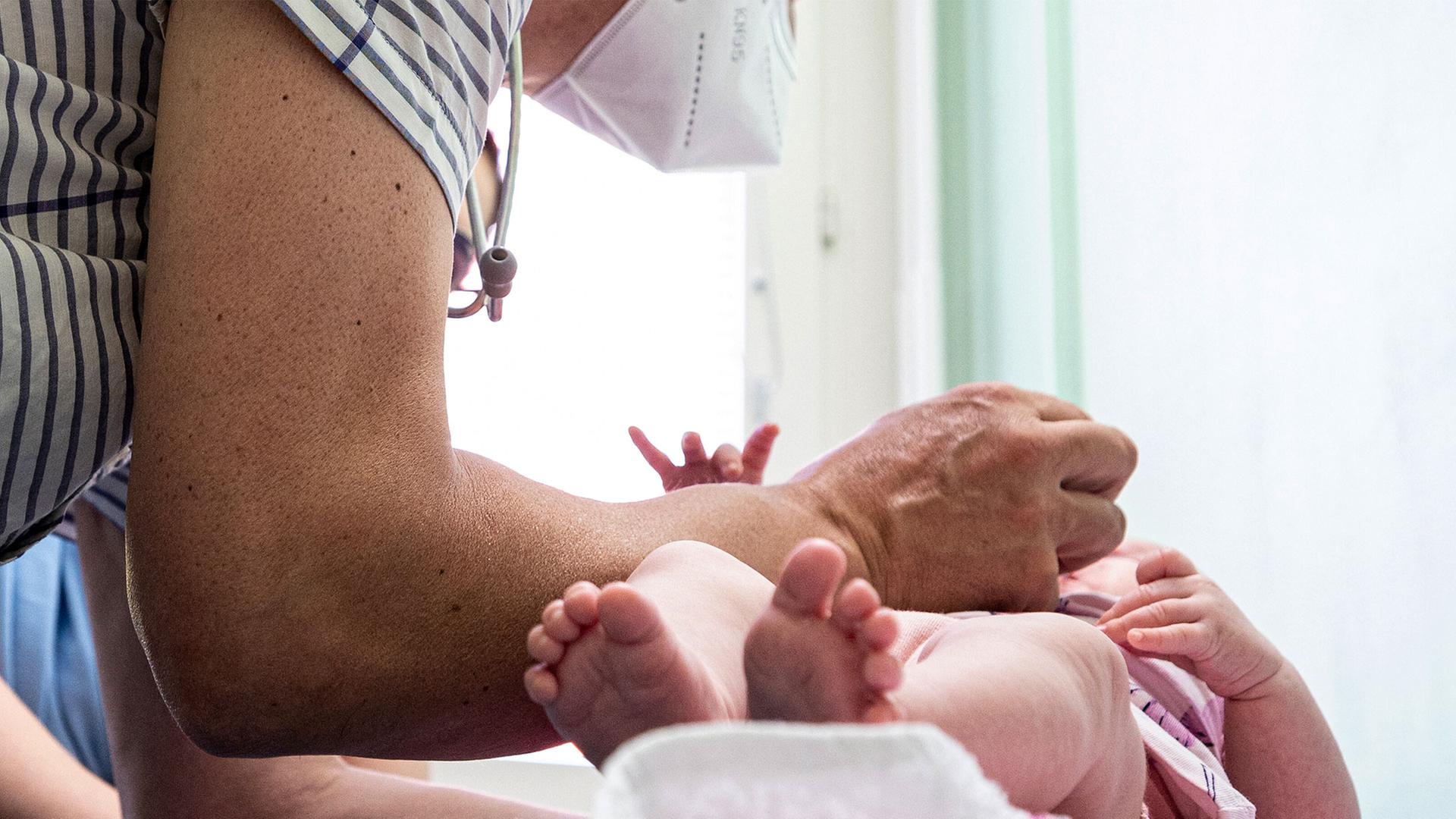 Ein Kinderarzt verabreicht einem Kleinkind eine Impfung. | picture alliance/dpa | Fabian Sommer