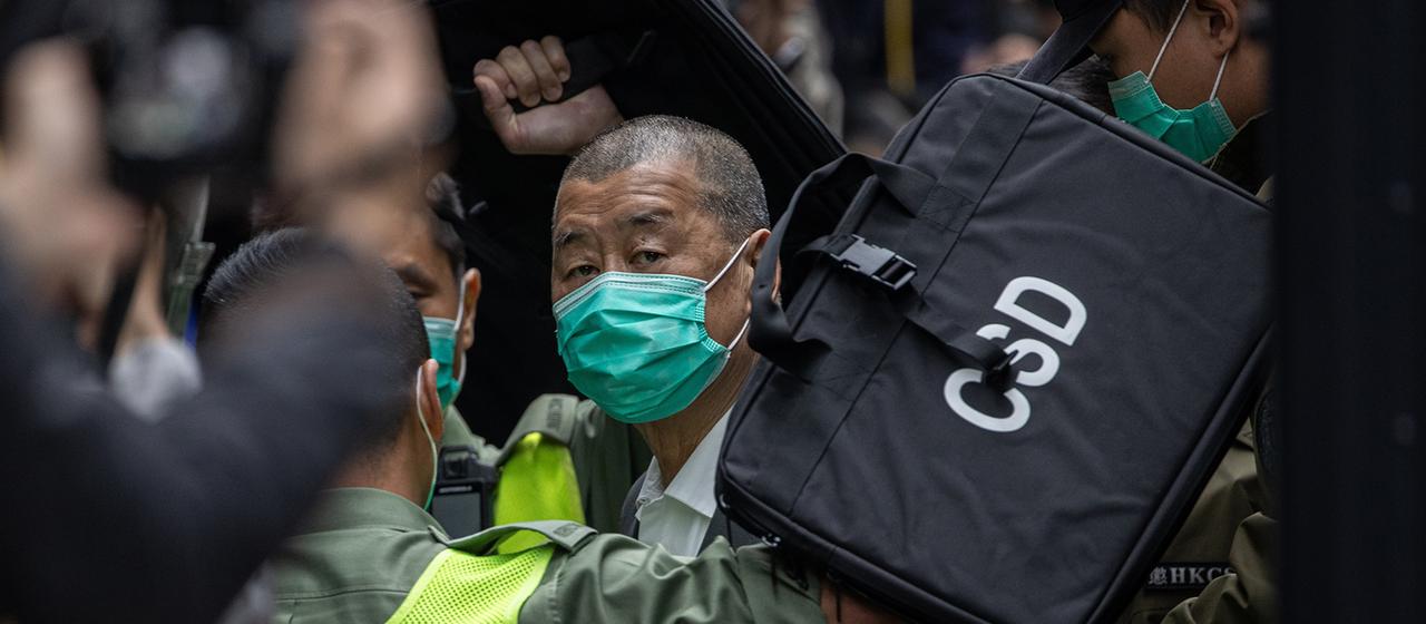 Jimmy Lai steigt in Hongkong, umringt von Sicherheitspersonal, aus einem Fahrzeug des Strafvollzugsdienstes.