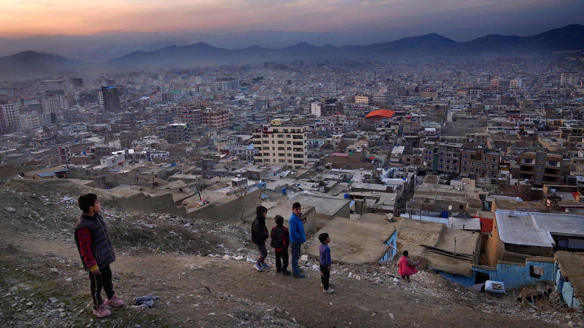 Jungen stehen auf einem Hügel mit Blick auf Kabul, Afghanistan. (Archivbild vom 27.02.2022) | AP