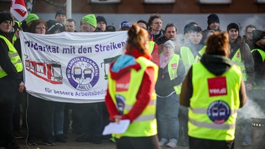 Mitarbeiter der Halleschen Verkehrs-AG (HAVAG) sowie Vertreter von Verdi und Fridays for Future stehen während eines Warnstreiks vor einem Betriebshof.