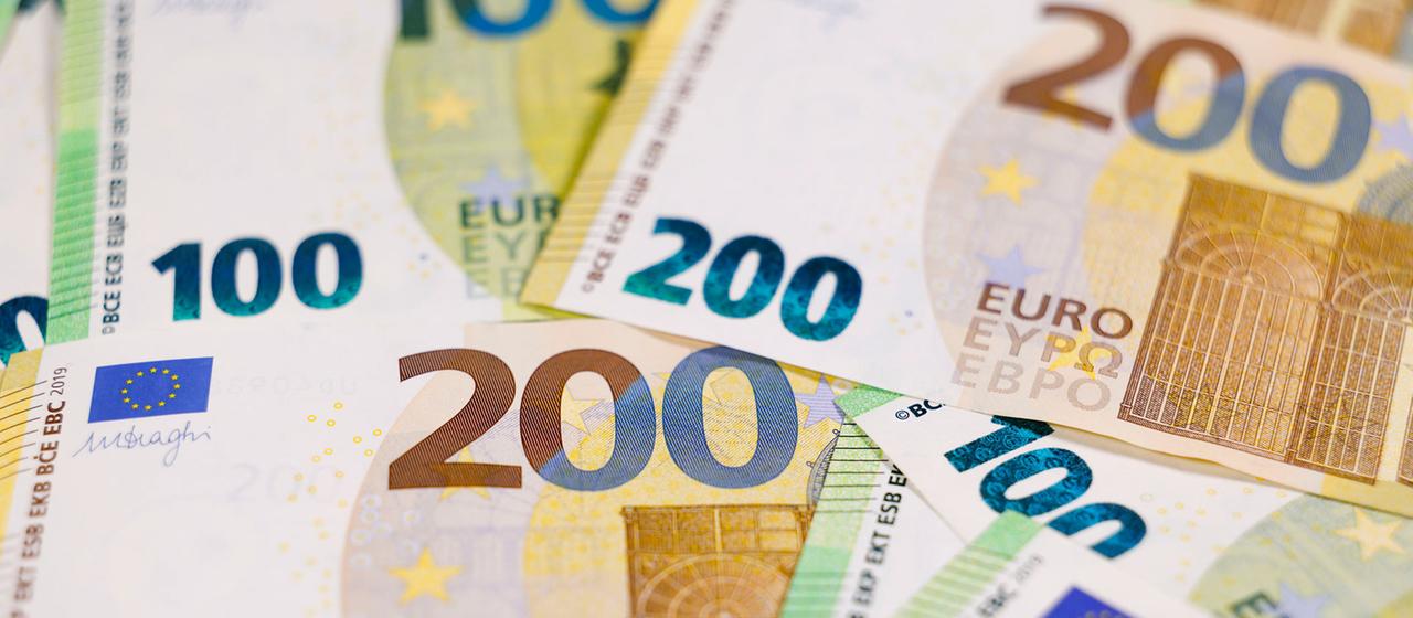 Zahlreiche Euro-Banknoten mit verschiedenen Werten liegen auf einem Tisch.