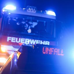 Feuerwehrfahrzeug und Streifenwagen mit Blaulicht und LED-Anzeige "Unfall"