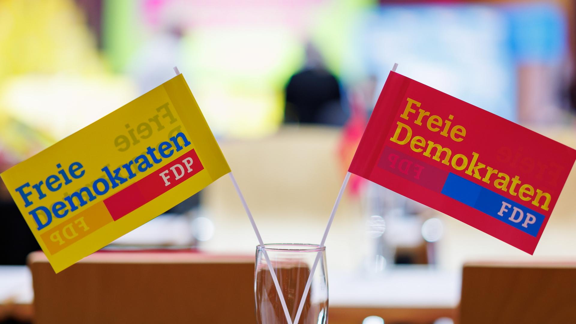 Zwei FDP-Fähnchen stehen in einem Glas auf einem Tisch. | dpa