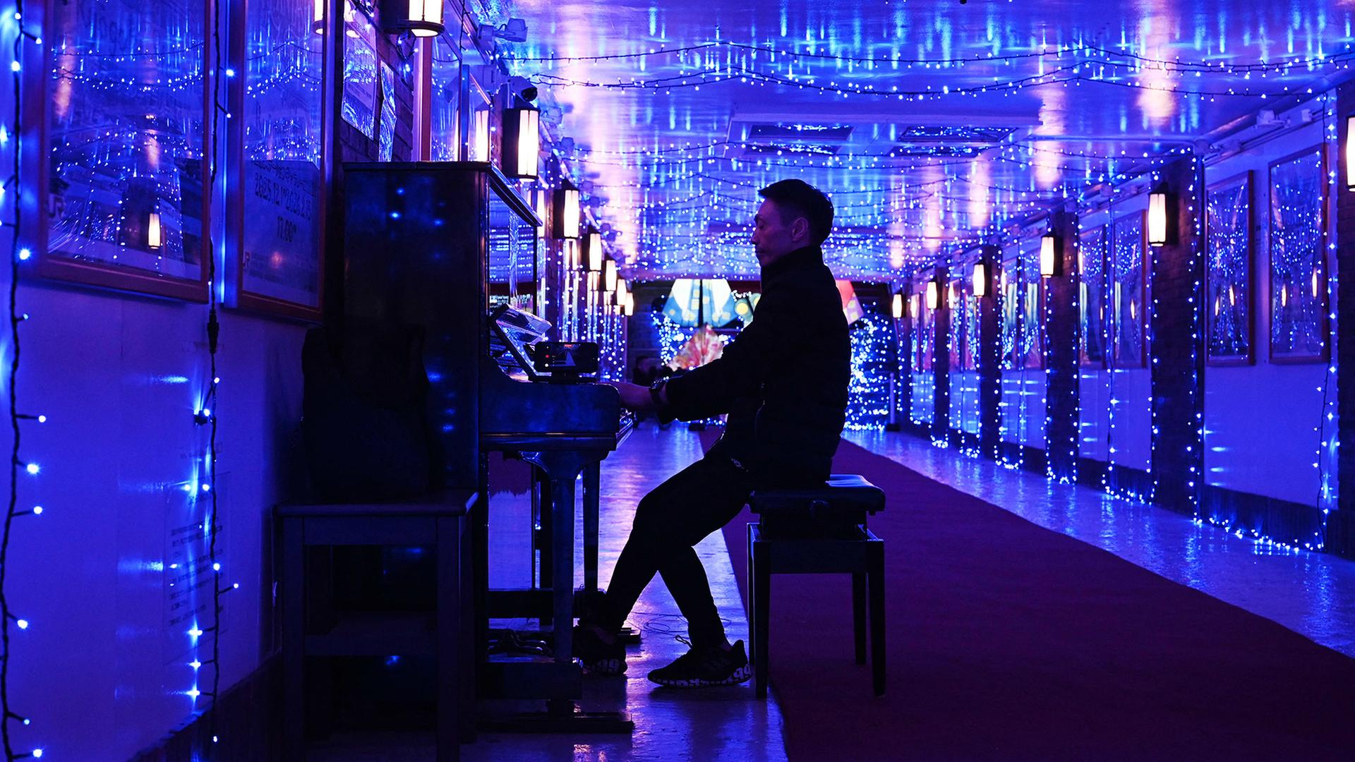 Ein Klavierspieler in blauem Licht | AFP