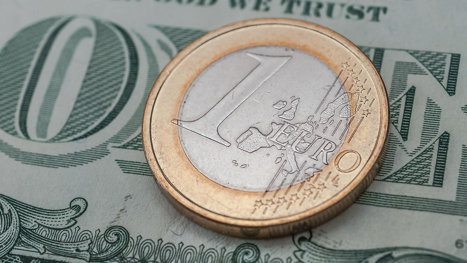 Euromünze auf einem Dollarschein. | picture alliance / Zoonar