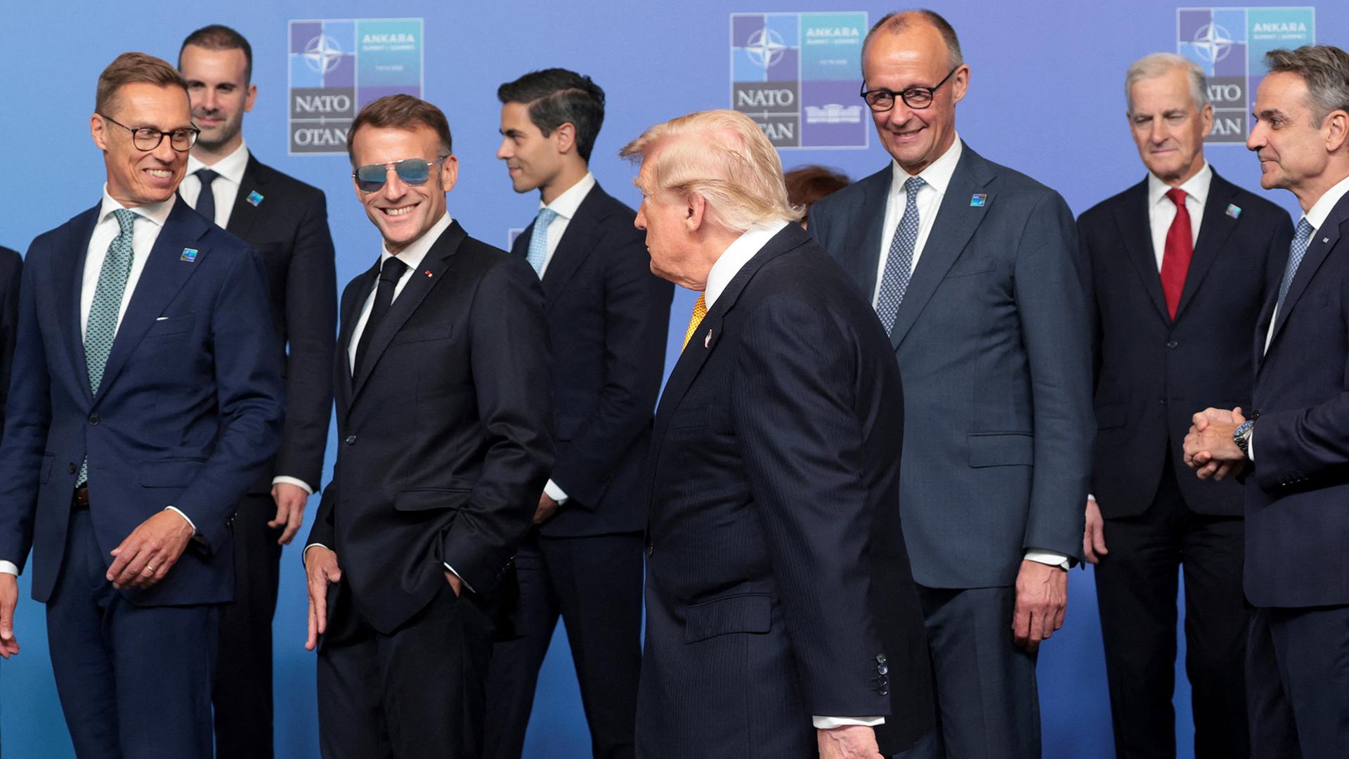 Donald Trump (m.) vor einer Gruppe, rechts hinter ihm: Friedrich Merz | REUTERS