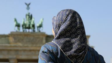 Frau mit Kopftuch vor Brandenburger Tor