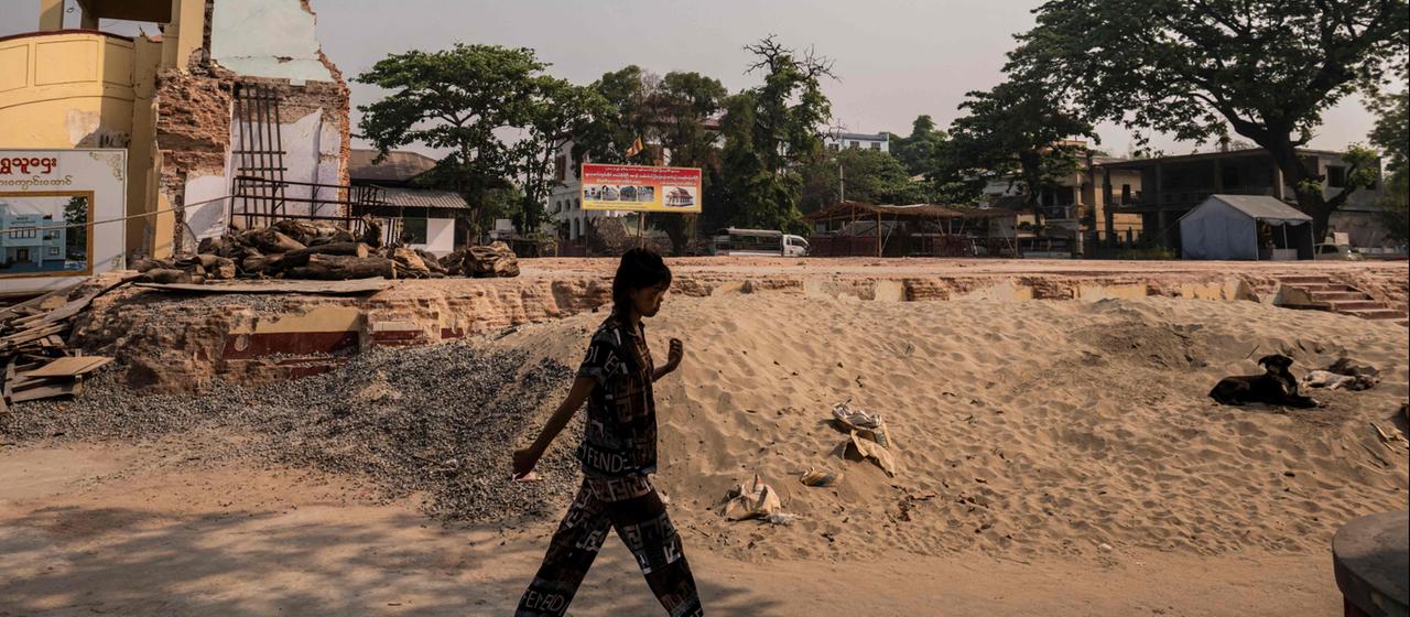 Ein Mädchen geht an einer Baustelle am Thahtay-Kyaung-Kloster in Mandalay vorbei