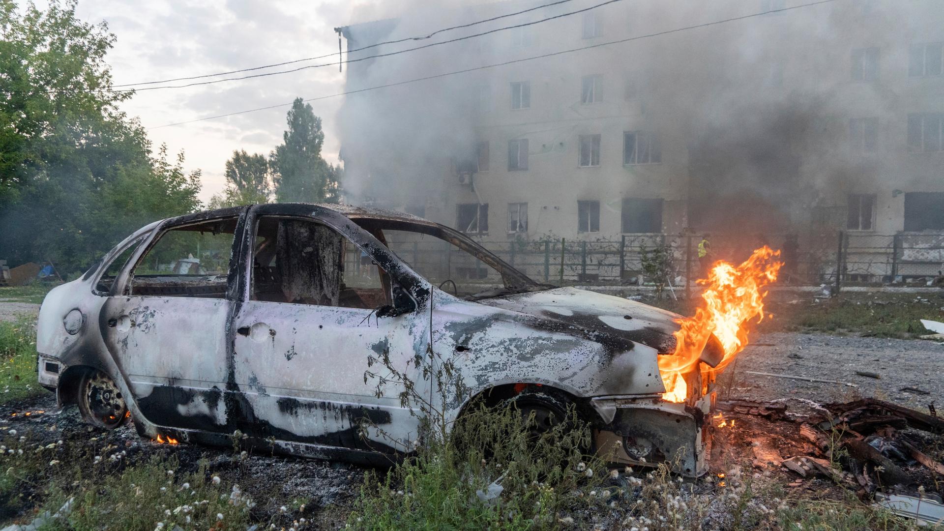 Ein brennendes weißes Auto nach einem russischen Raketenangriff auf Charkiw | dpa