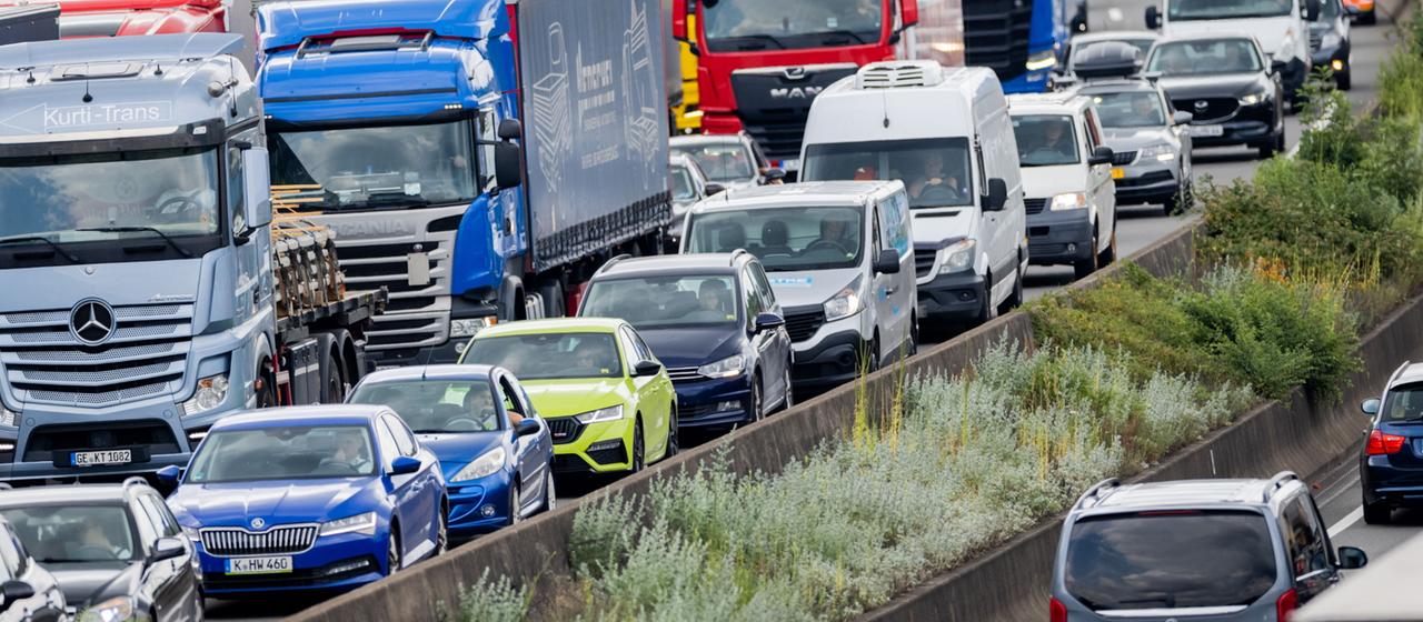 Autos und Lkw stauen sich auf der A3 im Autobahndreieck Köln-Heumar