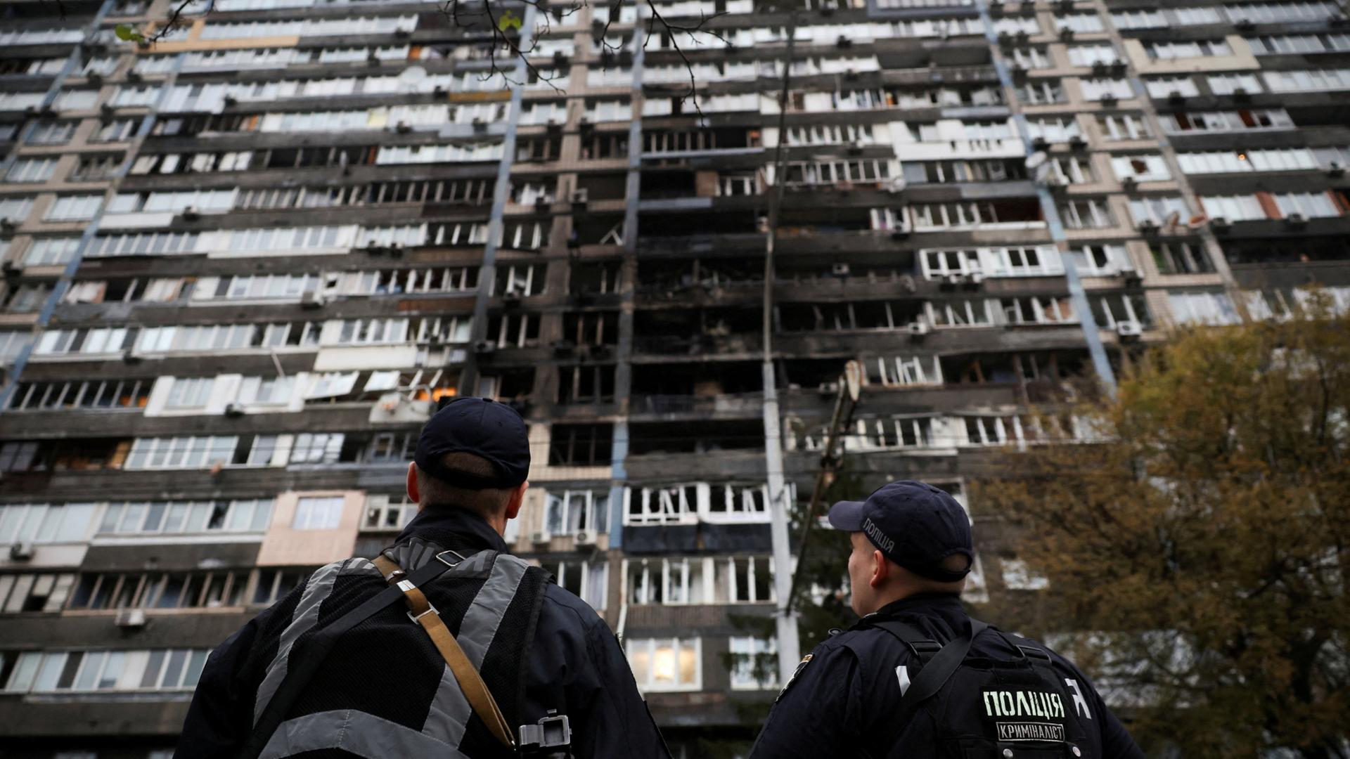 Einsatzkräfte der Polizei vor einem beschädigten Wohnhaus in Kiew | REUTERS