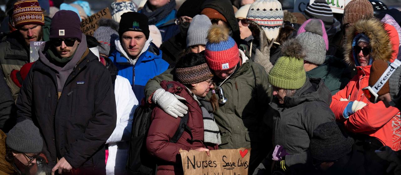 People in Minneapolis demonstrate with posters against the immigration authorities ICE.