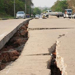 Fahrzeuge bahnen sich ihren Weg in der Nähe einer durch ein Erdbeben beschädigten Straße in Naypyitaw.