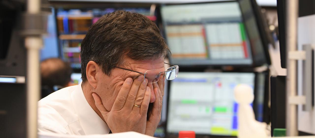 Ein Aktienhändler reibt sich auf dem Parkett der Frankfurter Wertpapierbörse die Augen.