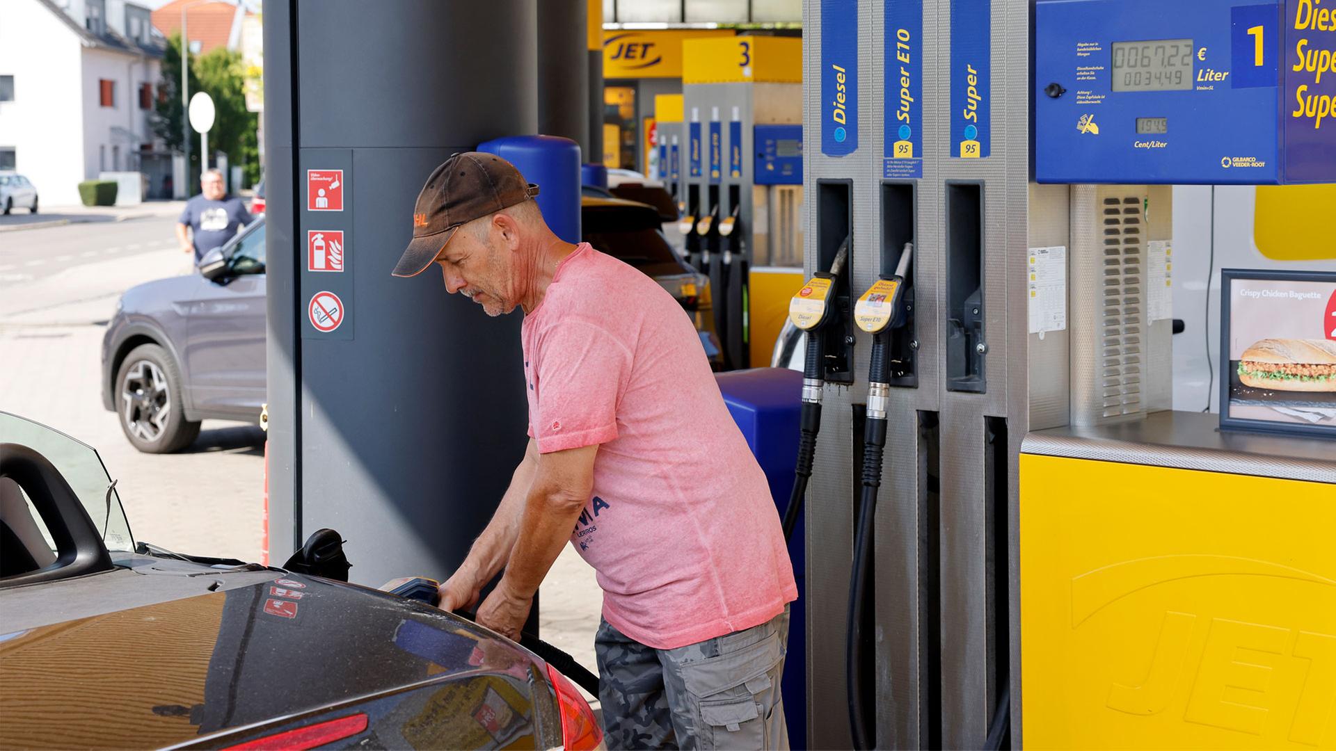 Ein Mann betankt sein Auto an einer Tankstelle. | picture alliance / SZ Photo