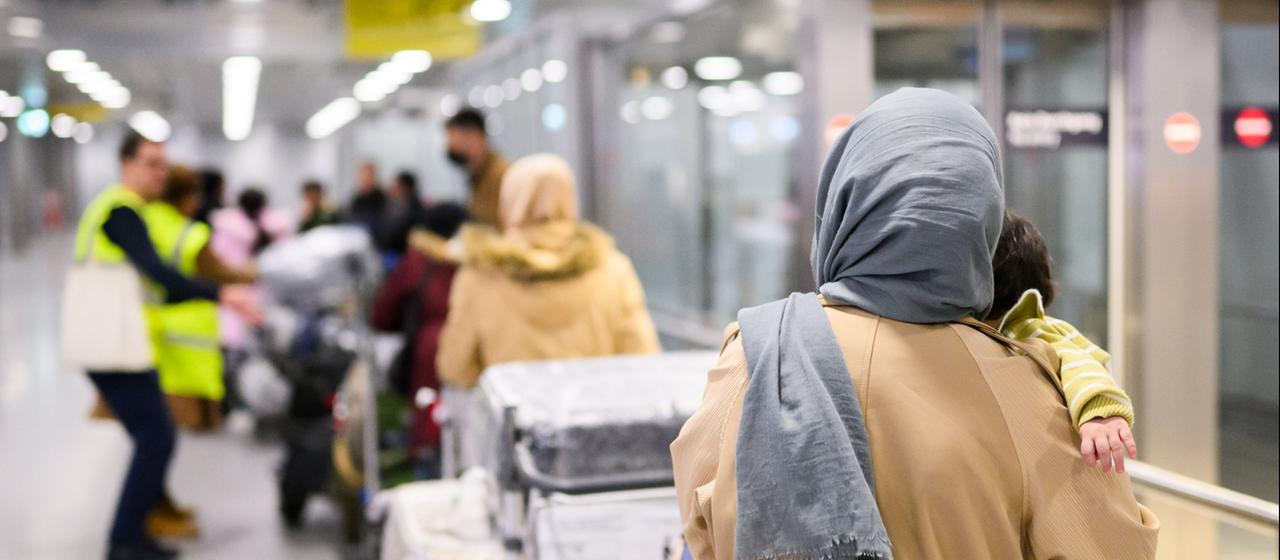 Afghaninnen und Afghanen aus den Bundesaufnahmeprogrammen stehen im Flughafen Hannover.