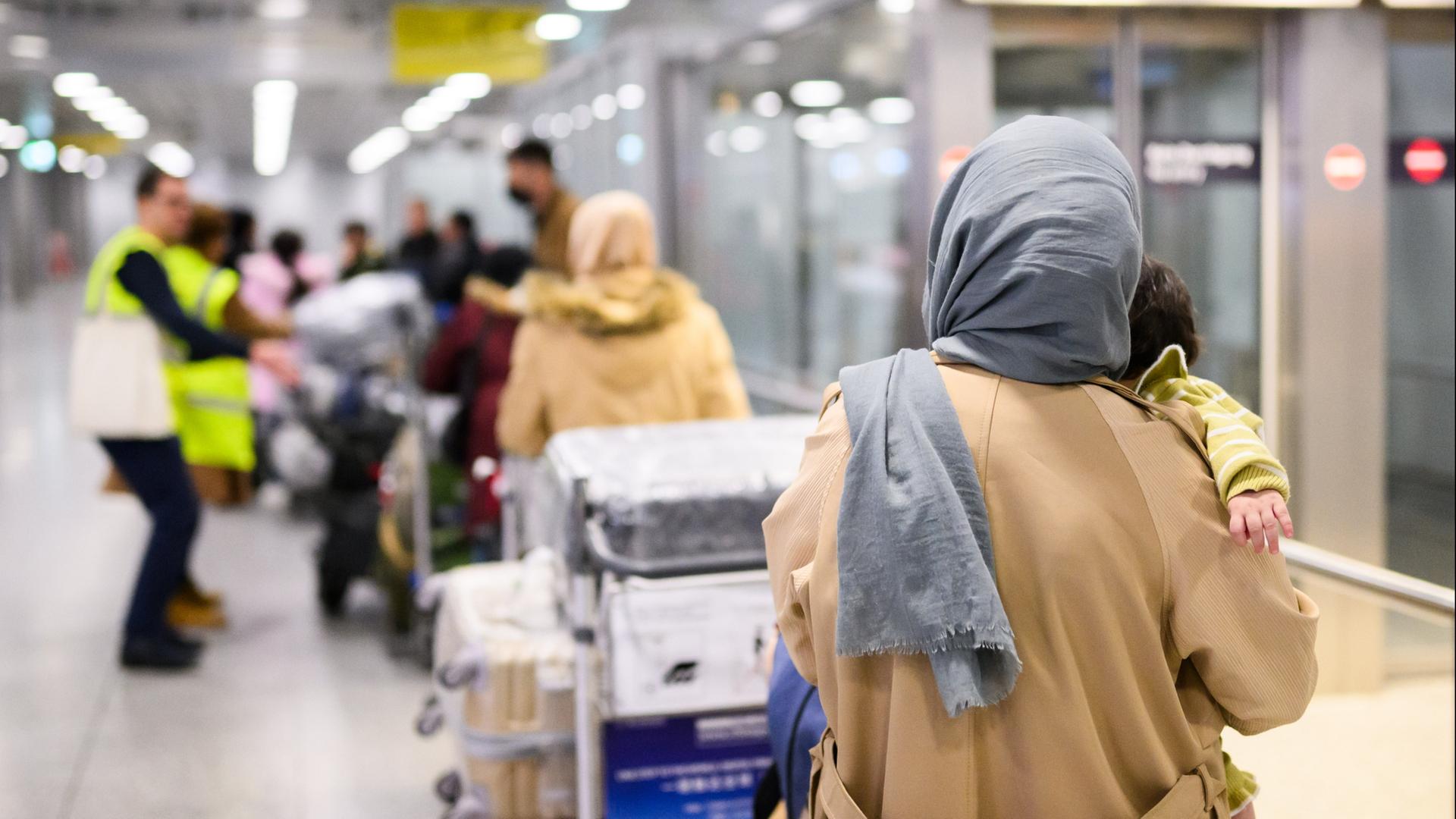 Afghaninnen und Afghanen aus den Bundesaufnahmeprogrammen stehen im Flughafen Hannover. | dpa