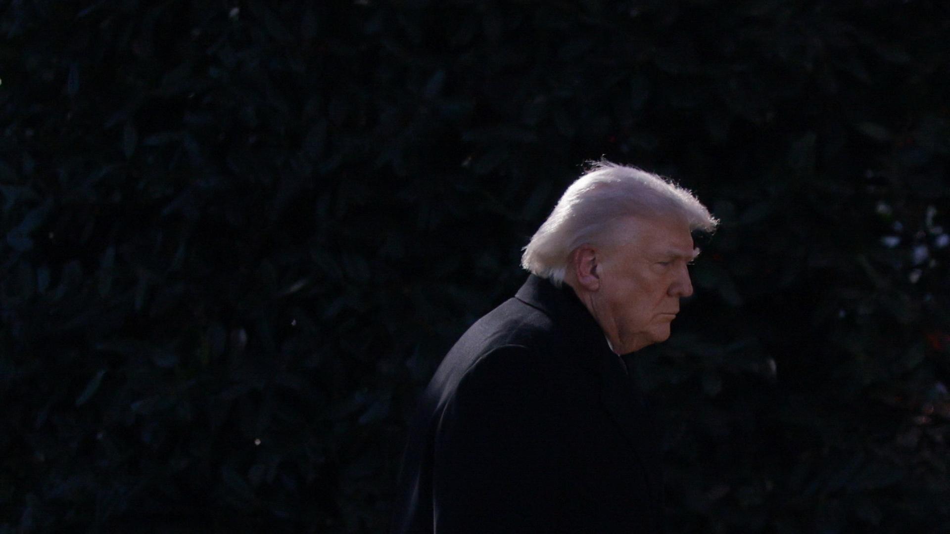 Donald Trump geht seitlich vor schwarzem Hintergrund an Kamera vorbei | REUTERS