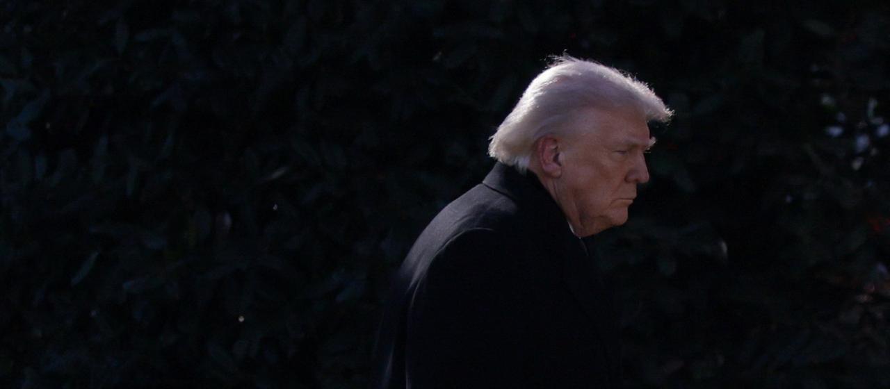 Donald Trump geht seitlich vor schwarzem Hintergrund an Kamera vorbei